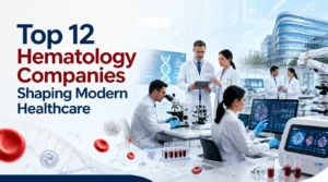 A professional blog banner titled "Top 12 Hematology Companies Shaping Modern Healthcare" featuring hematologists and researchers working in a high-tech laboratory with microscopes, blood samples, DNA graphics, red blood cells, diagnostic monitors, and advanced medical research equipment.